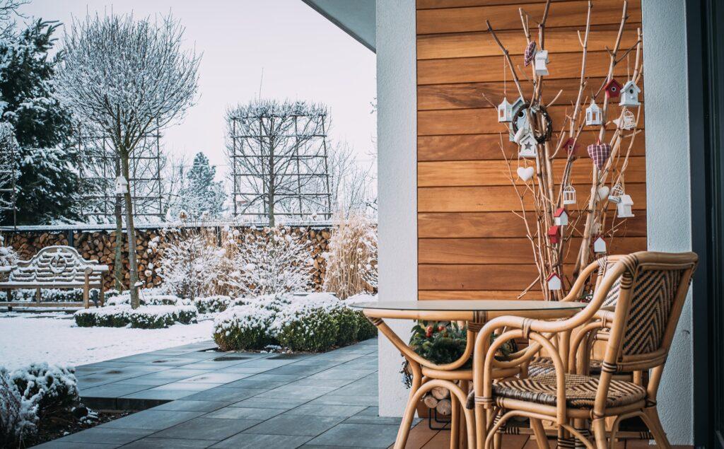 Gemütlicher Terrassenbereich mit Holzfassade und Winterdekoration | Sonnenschutz Markisen